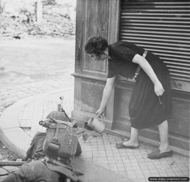 A French woman offers a glass of water to a Canadian soldier, 1944 